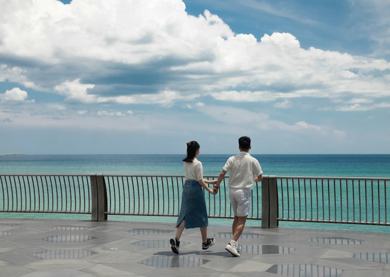 A couple walking hand in hand by the sea